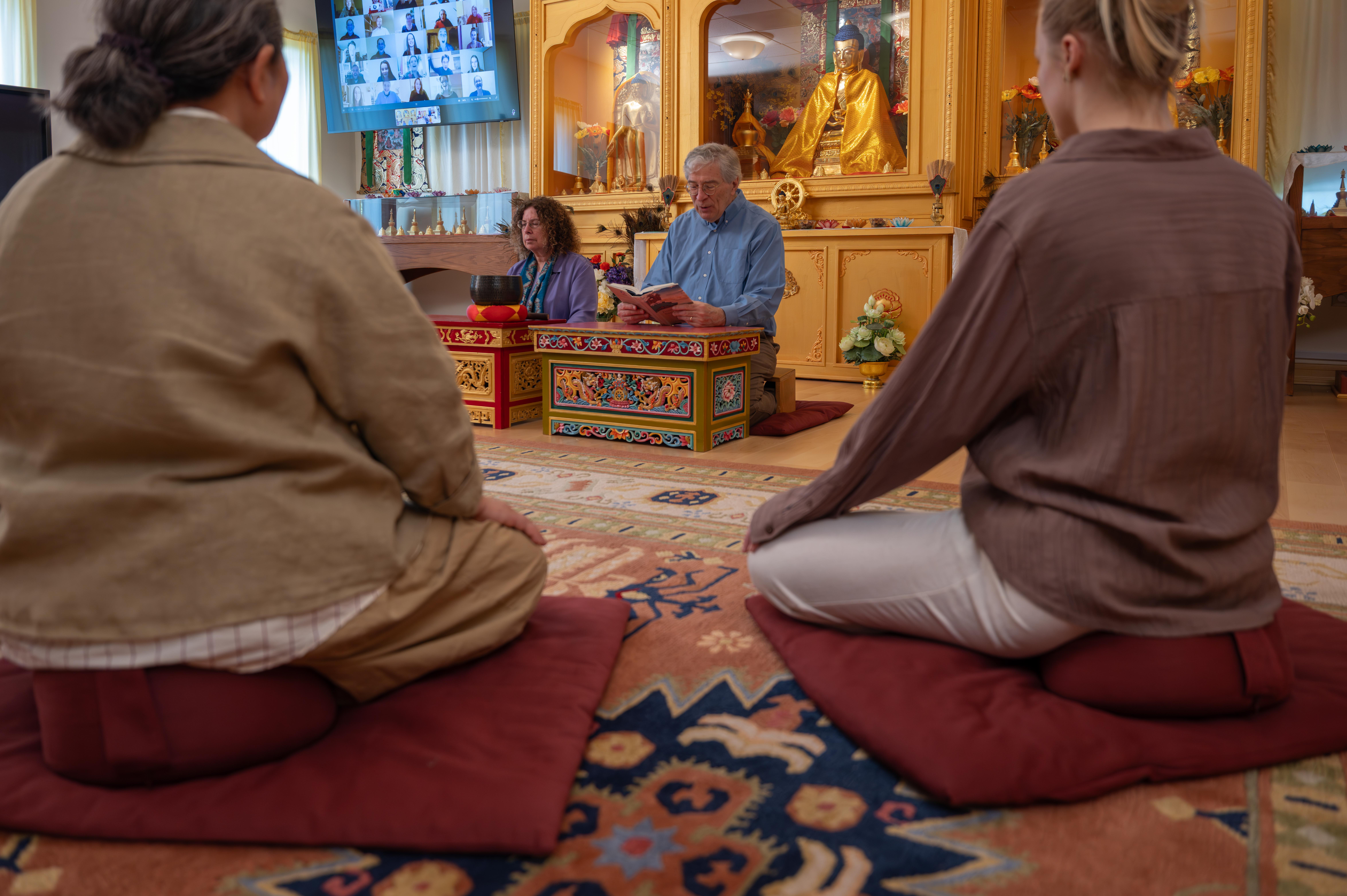 Students reading Tarthang Tulku's books together around a red table during a Nyingma Institute study session.