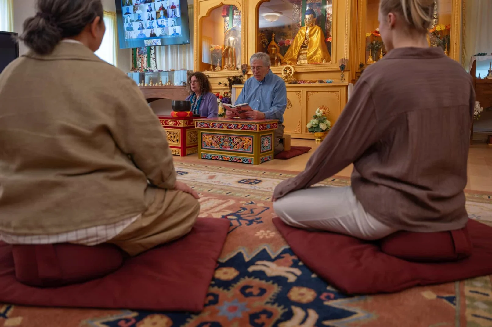 Students reading Tarthang Tulku's books together around a red table during a Nyingma Institute study session.